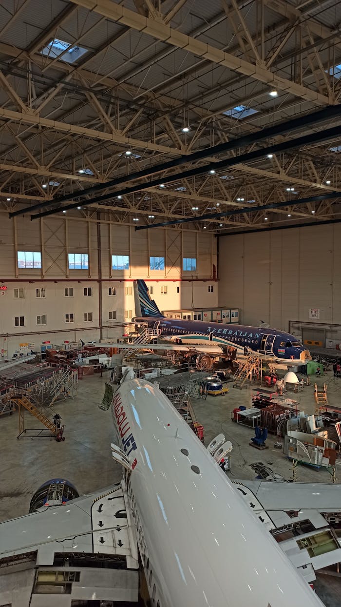 Services Interior view of a busy aircraft maintenance hangar with planes under repair.